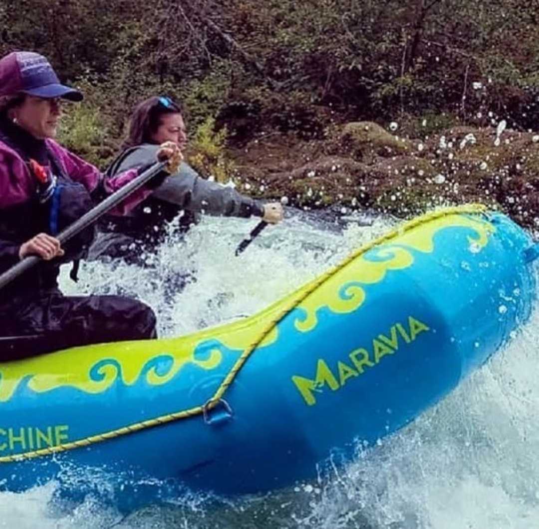 Individuals raft over white water.