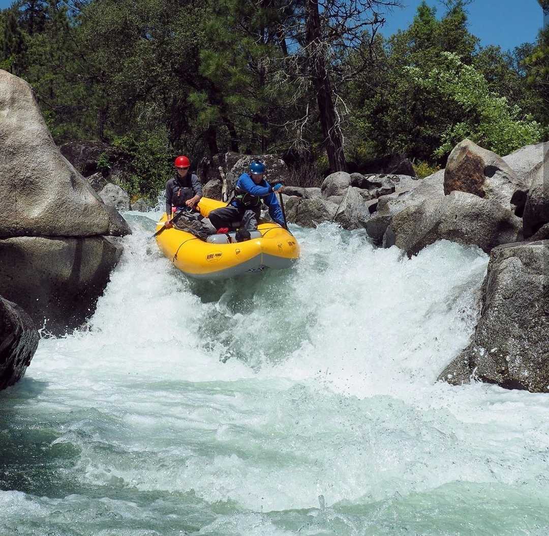 Individuals raft over white water.