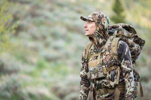 A hunter looks into the distance wearing First Lite clothing.