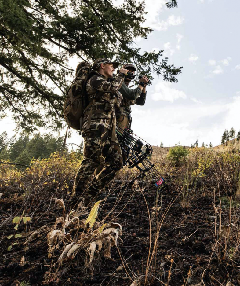 A hunter wears First Lite gear and stares into the distance.