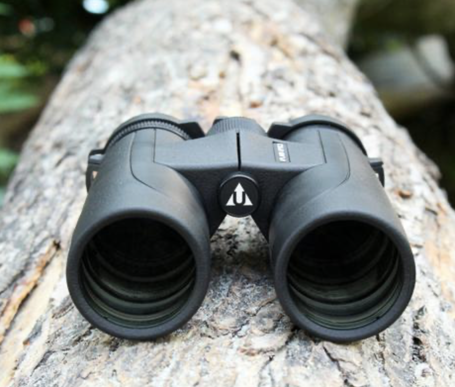 Upland Optics product sits on a tree log.