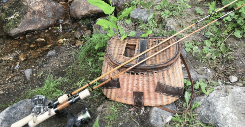 A headwaters bamboo rod sits on a fly fishing kit.