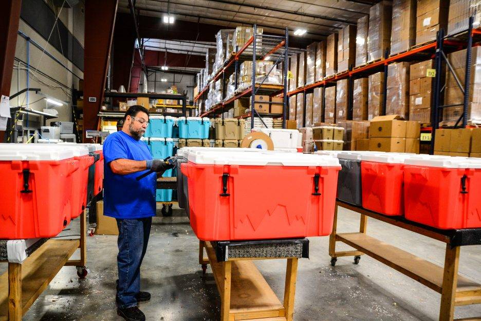 A man works on a cooler in the Cordova warehouse