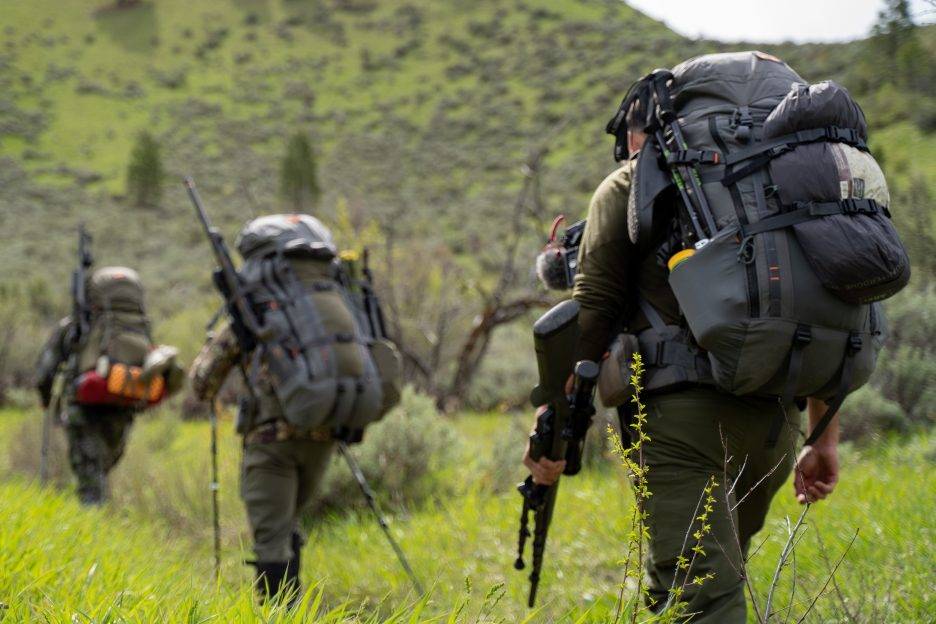 Three hunters walking navigating an Idaho mountain trail.