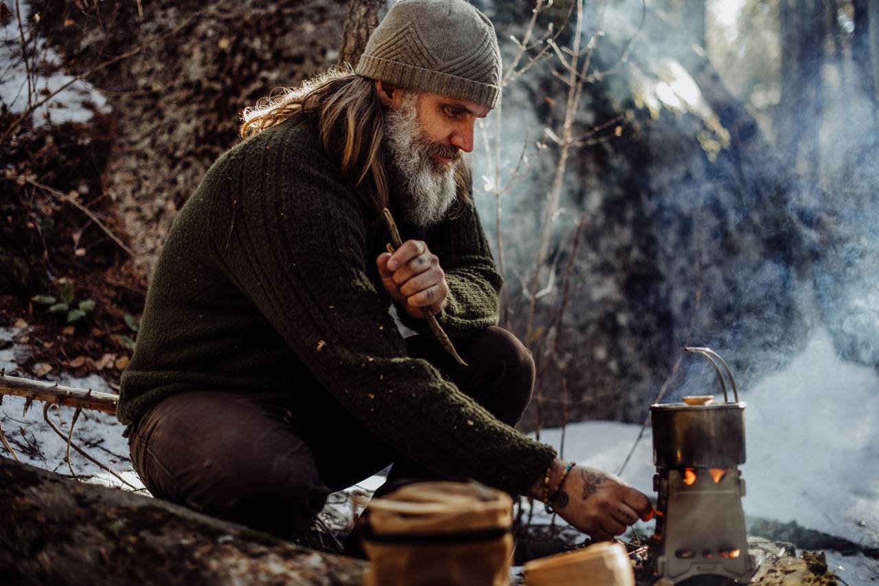 A man starts a fire using Überleben tools