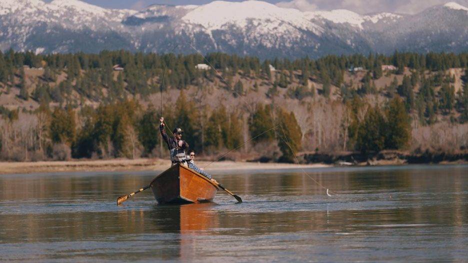 People in a driftwood on calm waters