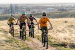 Four people riding bikes along a trail