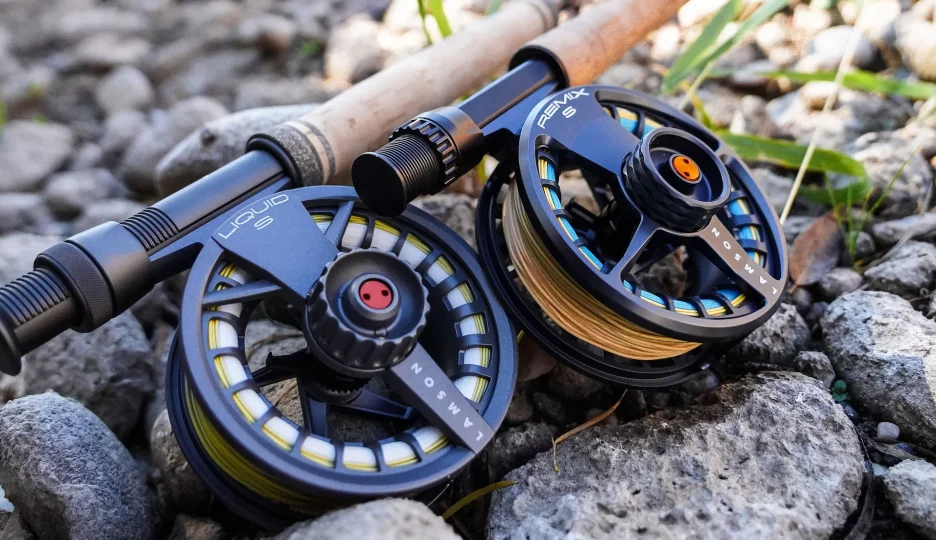 Two reels laying on some river rocks