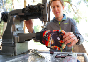An individual sews a chalk bag.