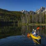 Two women kayak near the Sawtooths.