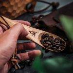 An individual scoops coffee bean using an Überleben tool