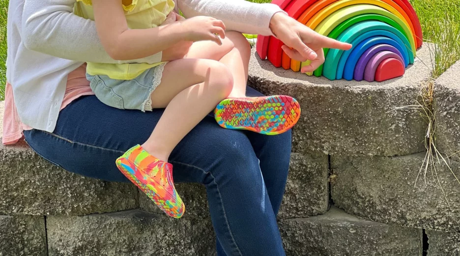 Child wearing Telic shoes sitting on mom's lap